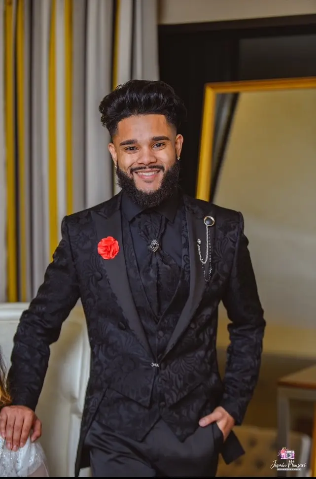 Styled dark hair with volume, worn with a black suit